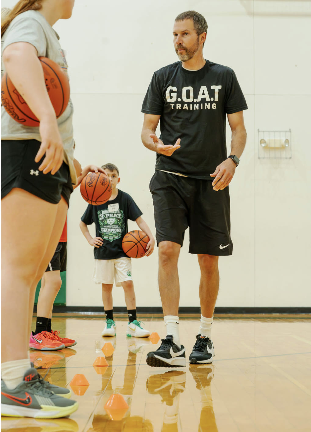 Coach Aaron Kowaleski coaching a group of young athletes